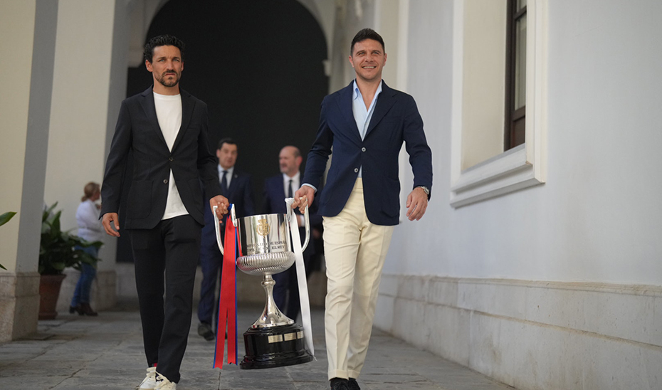 Jesús Navas y Joaquín Sánchez, ex futbolistas del Sevilla F.C. y el Real Betis Balompié, respectivamente, portan la Copa del Rey.